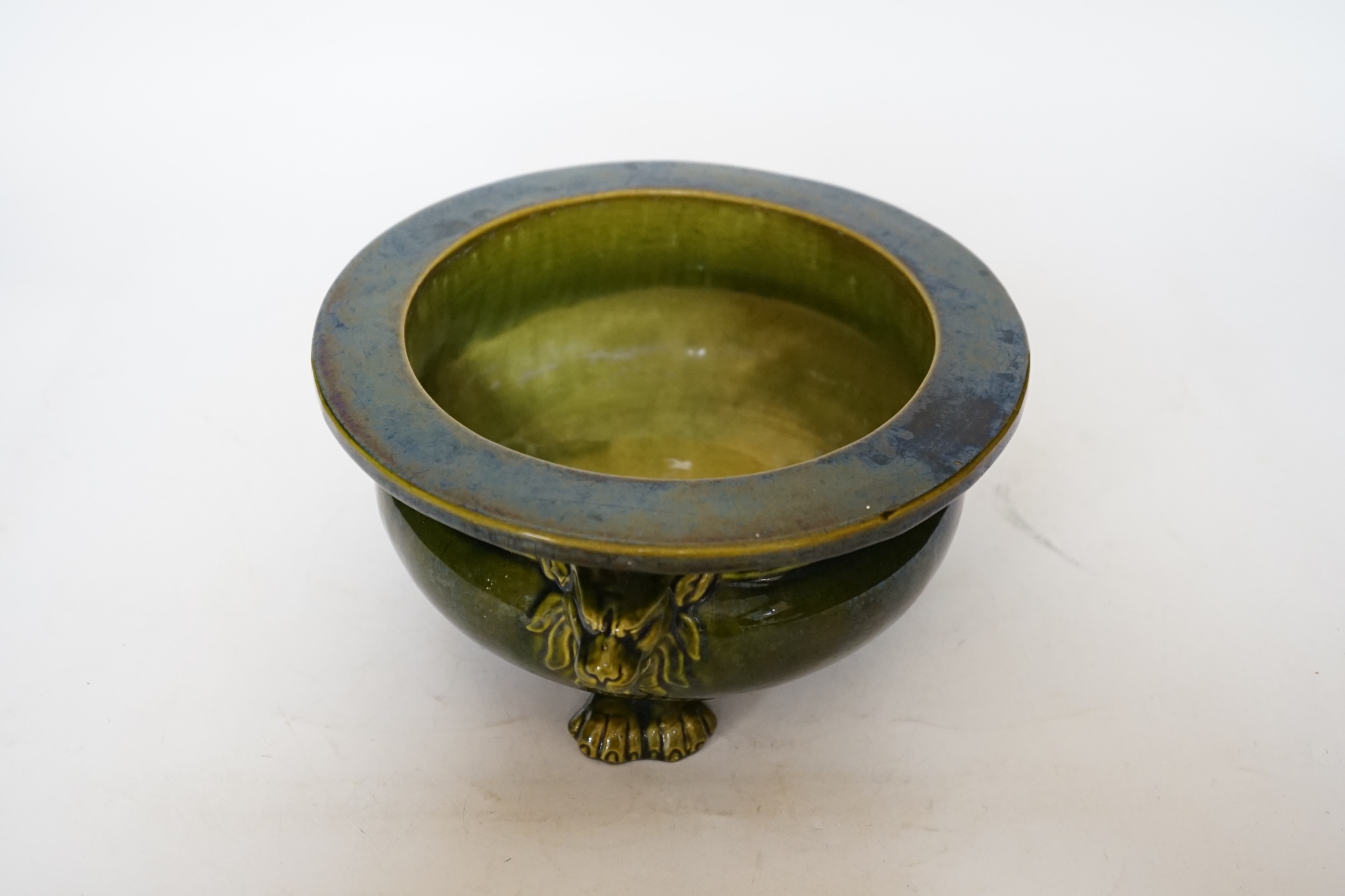 A green glazed Art pottery planter raised on three paw feet, diameter 20.5cm
